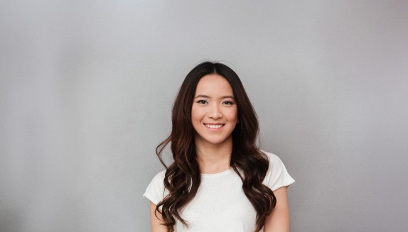 lächelnde Frau vor hellem Hintergrund